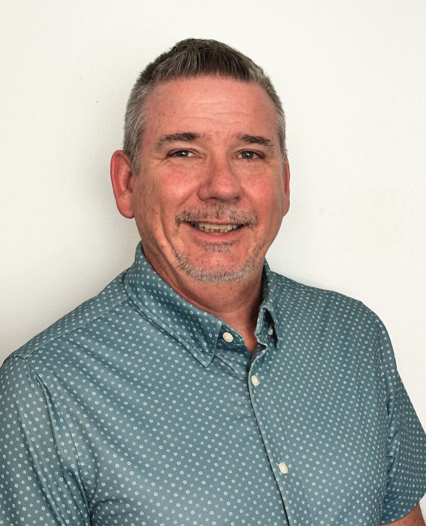 1. Professional man in business casual attire smiling, representing trusted home loan and mortgage broker services for future homeownership.