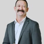 Justin Harwell in suit with light background