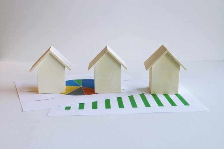 Several small model houses on paperwork, illustrating mortgage loan limits by property type.