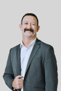 Justin Harwell in suit with neutral background