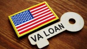 About Us 2 VA loan key with American flag patch, symbolizing government-insured home loans for veterans and active military.